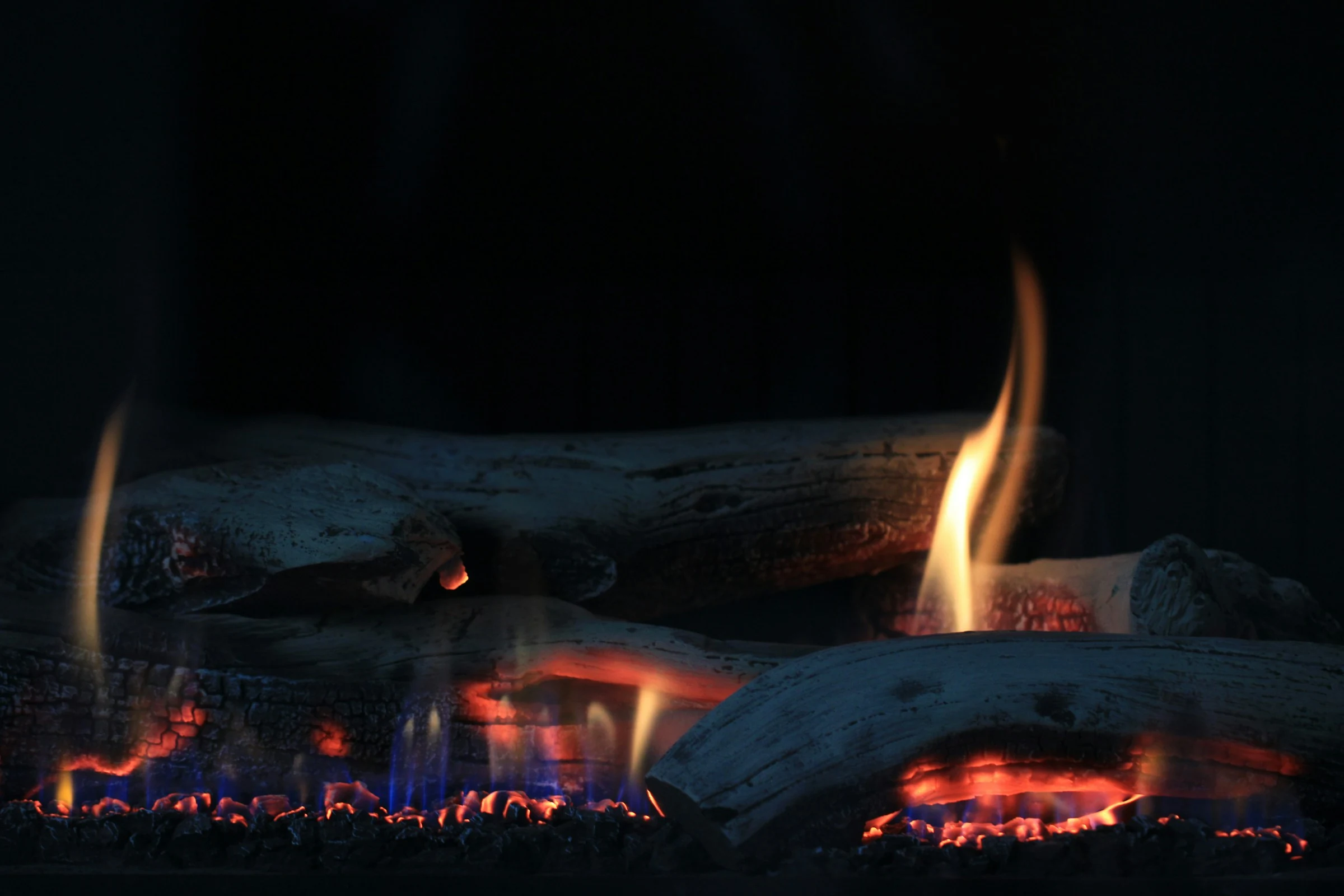 Gas-log fireplace with visible flames and glowing ember bed